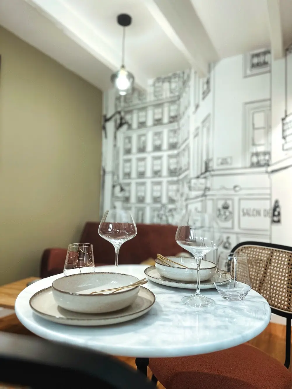 Coin repas avec table en marbre et chaises cannées dans un studio meublé