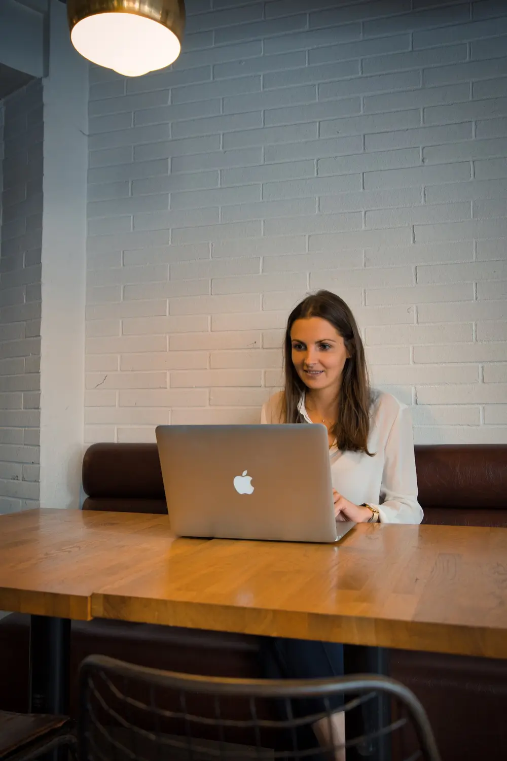 Une entrepreneuse travaille sur son ordinateur portable dans un café lumineux