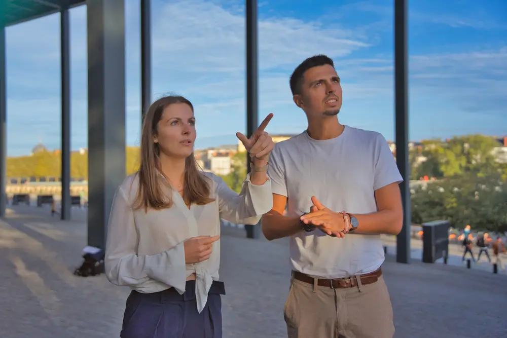 Une entrepreneuse et son associé en discussion sous une galerie en plein air