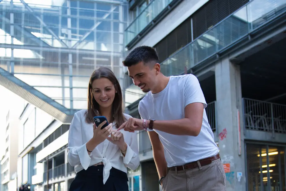 Deux associés échangent autour d'un smartphone devant leurs bureaux à Nantes
