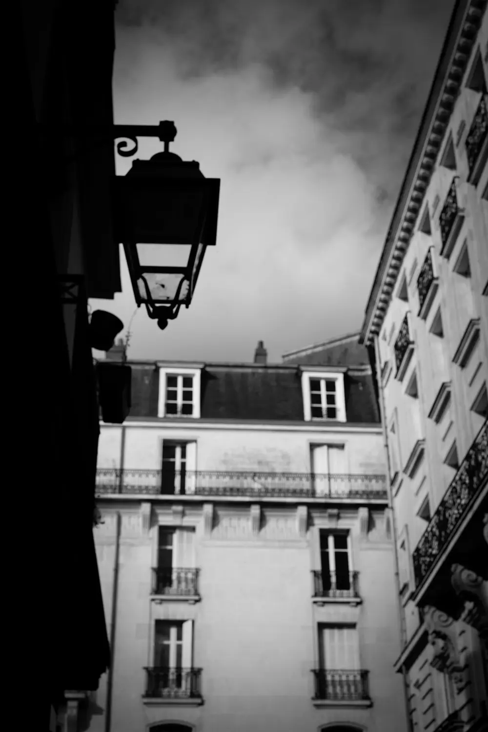 Façade d'immeuble ancien et lanterne en fer forgé en noir et blanc à Nantes