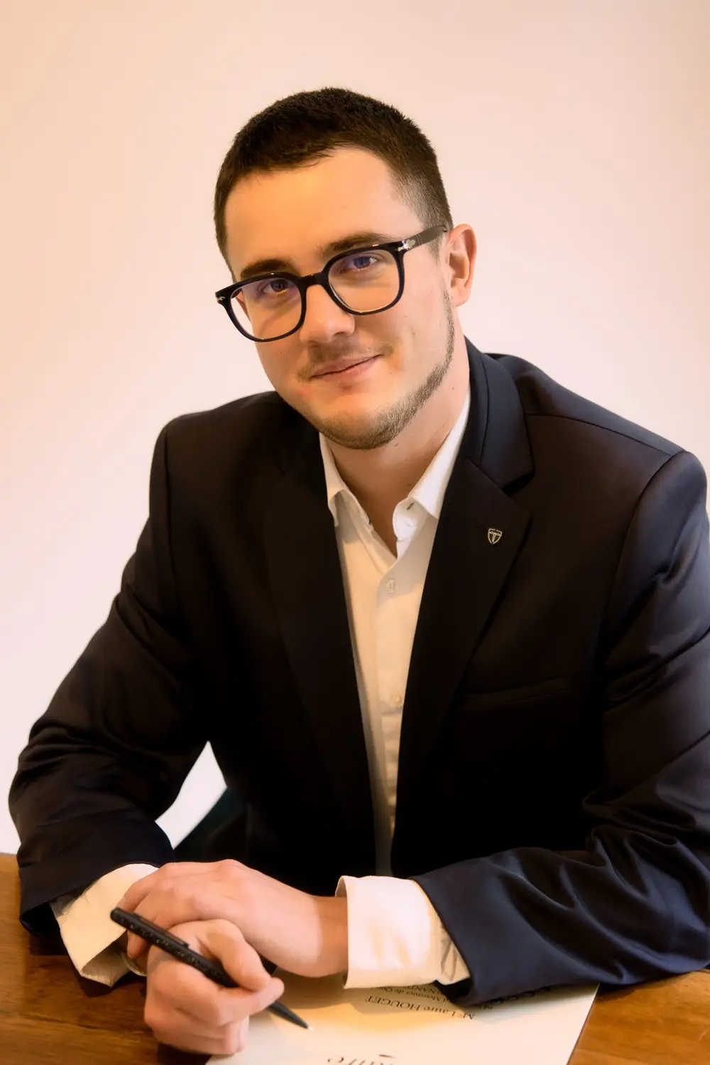 Portrait d'un dirigeant en costume signant un document à son bureau à Nantes