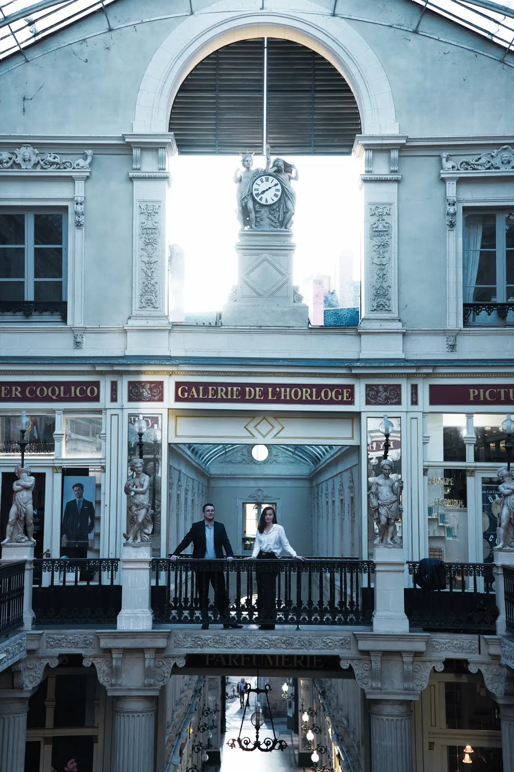 Vue d'ensemble de la galerie de l'Horloge avec les deux notaires accoudés au balcon