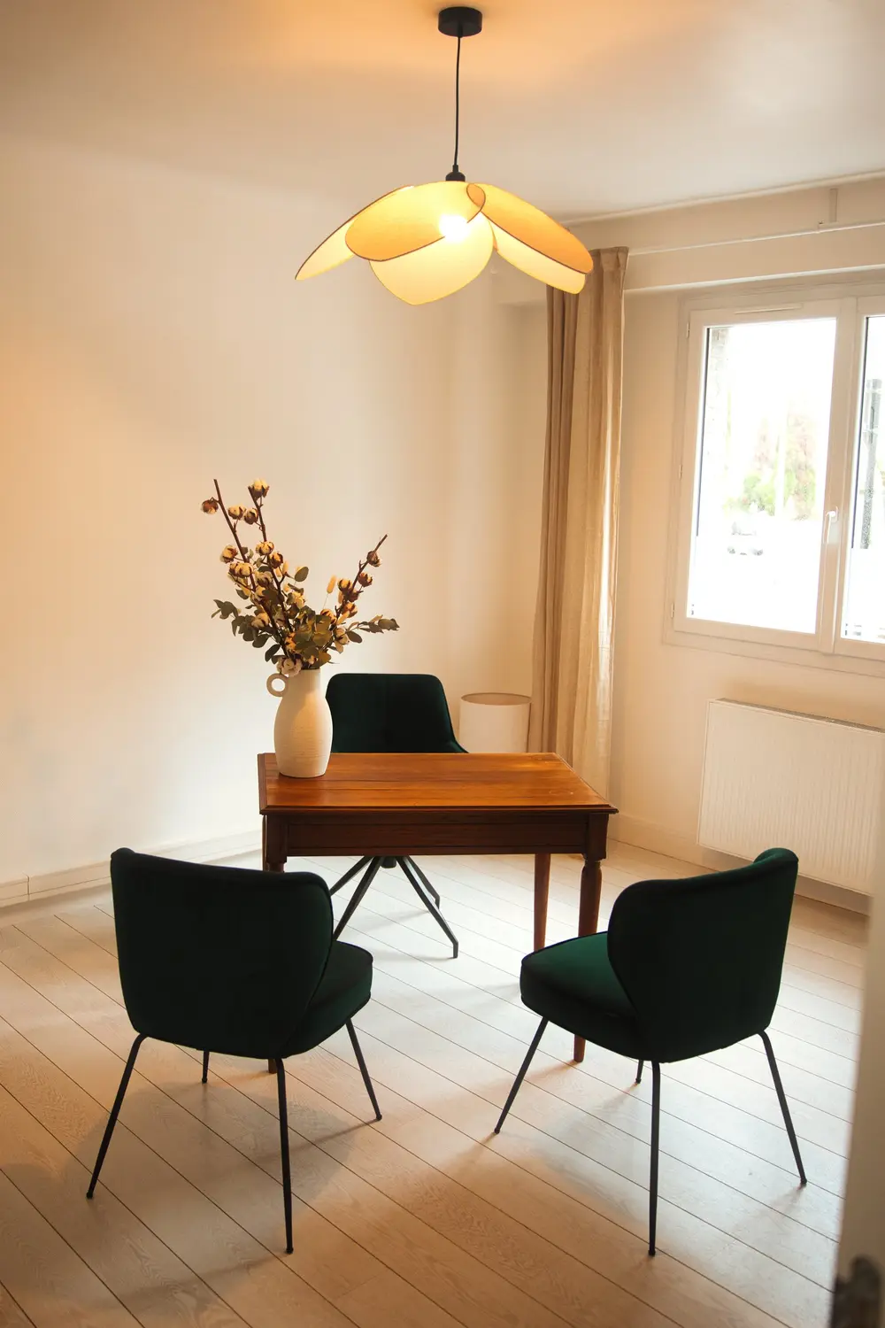 Salle à manger chaleureuse avec table en bois et chaises en velours vert