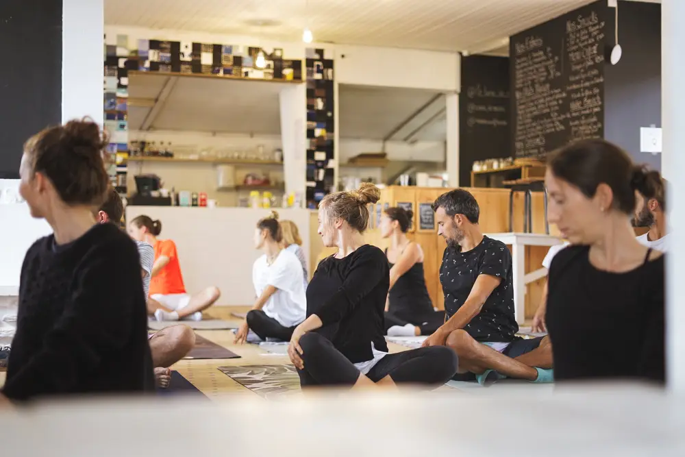 Participants assis en tailleur lors d'une séance de yoga en entreprise