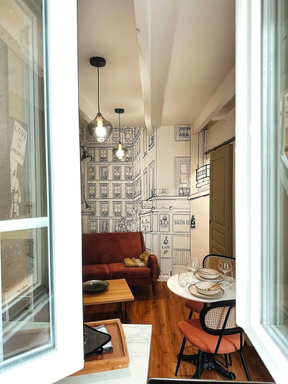 Vue d'ensemble d'un studio meublé avec canapé rouille et coin repas à Nantes